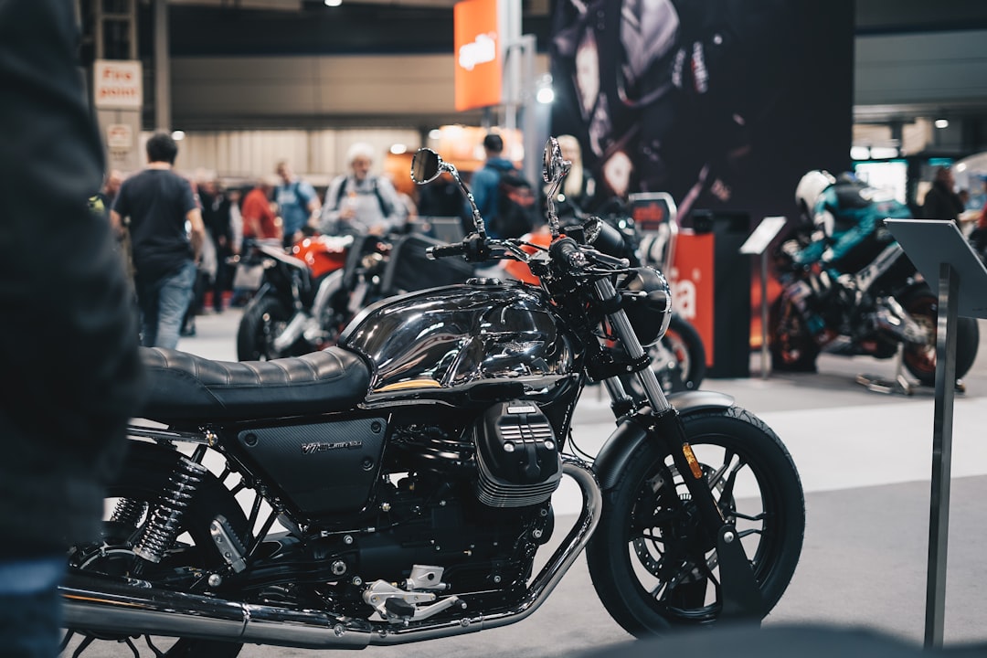 a-black-motorcycle-parked-in-front-of-a-crowd-of-people-i6hvy4a5ohg
